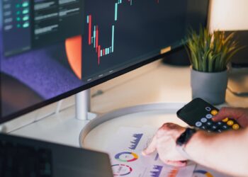 CEO sitting at a desk, surrounded by financial reports and cryptocurrency charts, looking contemplative.