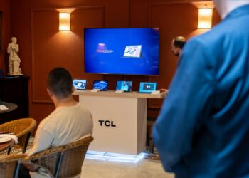 Engineers discussing chip designs at a tech conference, showcasing xAI's Terafab initiative.