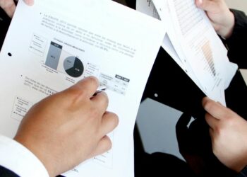 Wall Street analysts reviewing financial charts related to SpaceX IPO and Grok AI subscription.