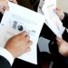 Wall Street analysts reviewing financial charts related to SpaceX IPO and Grok AI subscription.