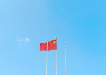 Chinese flags in front of AI technology graphics, symbolizing IP theft allegations.