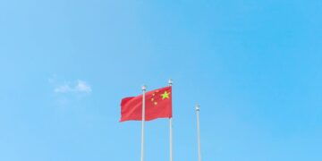 Chinese flags in front of AI technology graphics, symbolizing IP theft allegations.
