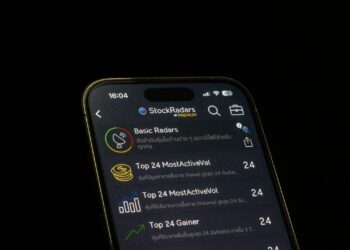 User interface of a fraudulent Ledger Live app with warning signs and money graphics.