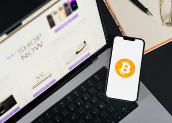 Bithumb logo displayed on a smartphone with Bitcoin graphics in the background.