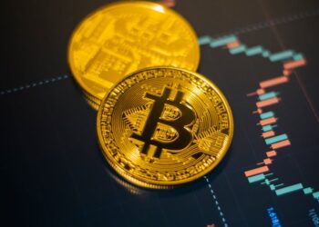 Bitcoin coins stacked with a declining graph overlay, symbolizing market volatility.