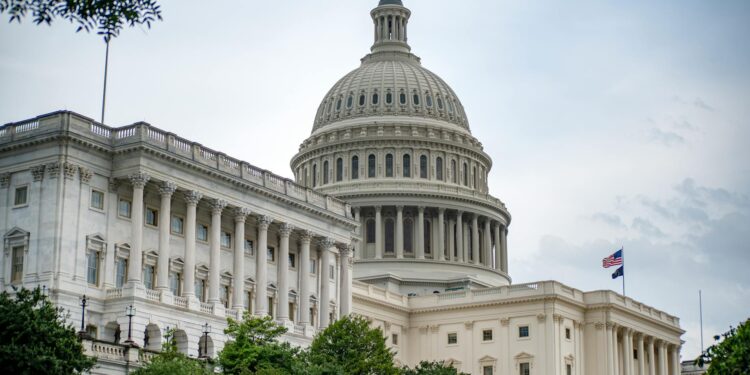 Kevin Warsh testifying before Congress about financial conflicts during his Fed nomination.