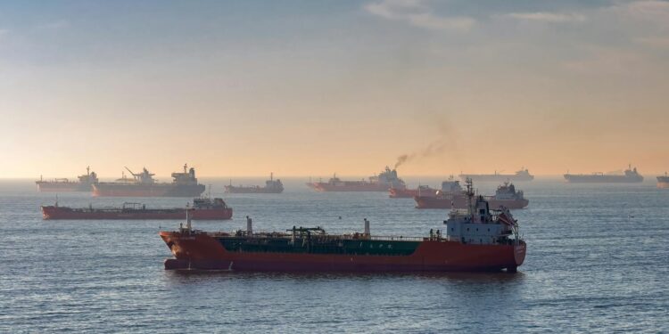 Oil tankers navigating the Strait of Hormuz with a Bitcoin symbol overlay representing taxation.