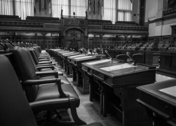 A legislative chamber with lawmakers debating a bill on online gambling regulations.