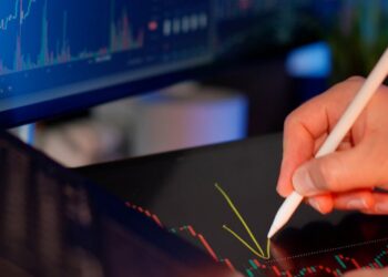 A financial analyst examines charts reflecting cryptocurrency market declines.