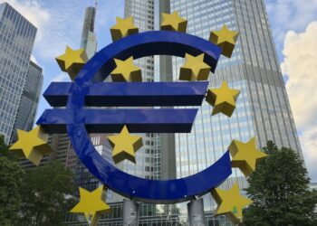 European Central Bank building with digital currency symbols superimposed.