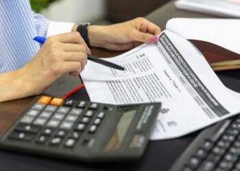 Legislator reviewing documents on stablecoins and financial regulation at a desk.