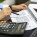 Legislator reviewing documents on stablecoins and financial regulation at a desk.