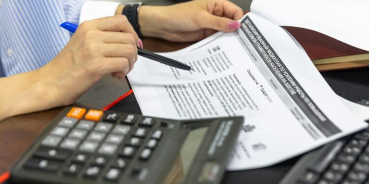 Nishad Singh seated at a desk, reviewing financial documents related to cryptocurrency regulations.