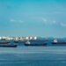 U.S. Navy ships positioned near Iranian ports as oil prices rise dramatically.