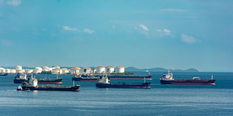 Oil tanker in port with Bitcoin symbol overlay, highlighting crypto use amid sanctions.