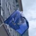 Clearbank Europe team celebrating in front of the Dutch flag, marking their EU crypto license approval.