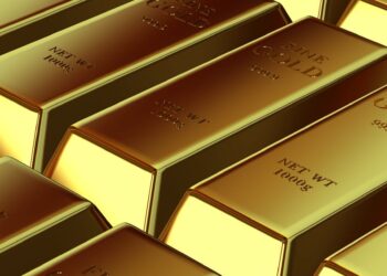 Gold bars stacked on a table, symbolizing falling gold prices amid economic uncertainty.