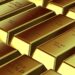 Gold bars stacked on a table, symbolizing falling gold prices amid economic uncertainty.