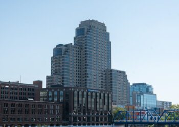 Bet365 logo with a backdrop of Michigan's skyline and sports symbols representing betting.