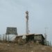 Bitcoin mining equipment with solar panels in a remote area, symbolizing off-grid technology.