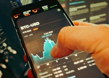 Hands shaking over a trading screen displaying crypto market trends and World Cup graphics.