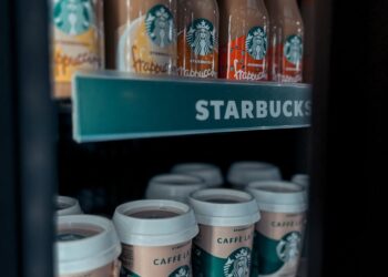 Barista using a tablet to suggest personalized drinks with LattAI app at a Starbucks store.