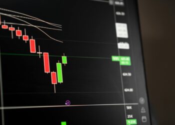 A dark screen with stock charts and a warning sign, representing a trading suspension.