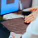A developer uses a no-code AI app builder on a laptop in a modern workspace.