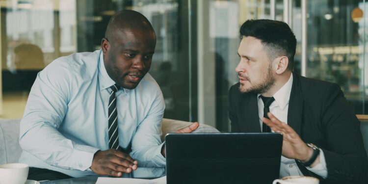 Two business professionals discussing stablecoin technology at a modern office.