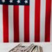 Digital currency symbols overlaying U.S. flag with cash and Republican campaign materials.