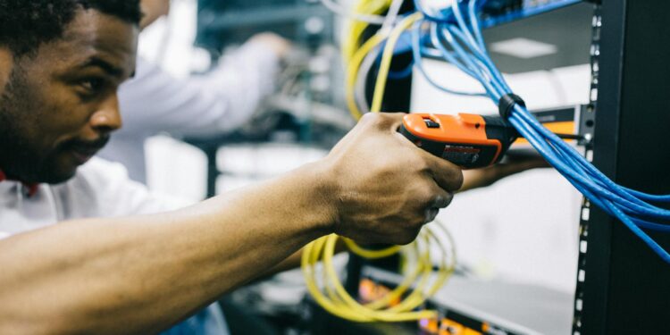Technician repairing server in a data center during ChatGPT service disruption.