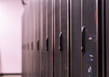 Aerial view of a large data center with servers and cooling systems, showcasing tech infrastructure.
