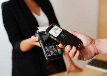 A person uses a smartphone to make a crypto payment at a retail store.