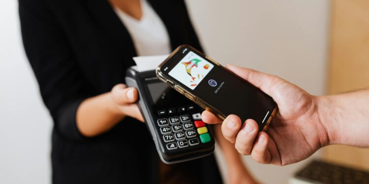 A person uses a smartphone to make a crypto payment at a retail store.