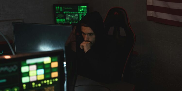 A hacker at a computer, with cryptocurrency symbols and a Russian flag in the background.