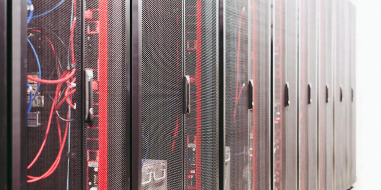 Two engineers working on advanced TPU servers with Google and Broadcom branding visible.