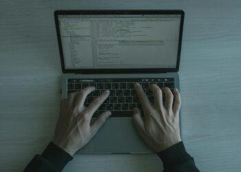 A cybersecurity expert analyzes code on a laptop, revealing vulnerabilities in software.