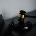 A gavel rests on financial documents, symbolizing justice for OneCoin fraud victims.