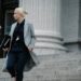 A woman standing in front of a courthouse, linked to a Bitcoin fraud case.