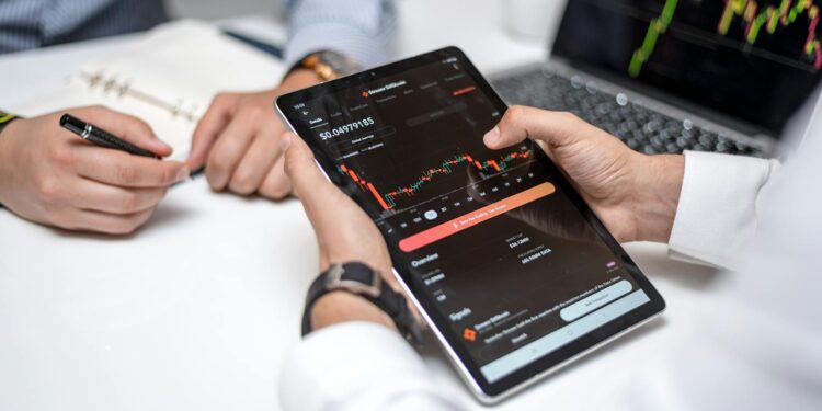 A financial professional reviewing PEPE cryptocurrency data on a digital tablet.