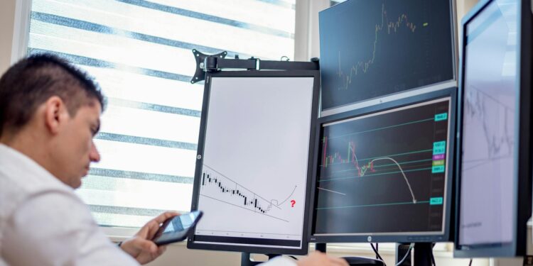 Traders analyzing stock market charts with election prediction market data on screens.