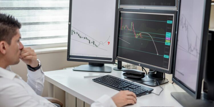 A financial analyst examines stablecoin yield graphs and data on a computer screen.