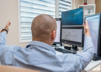 Traders monitoring stock market charts on screens reflect positive financial sentiment.