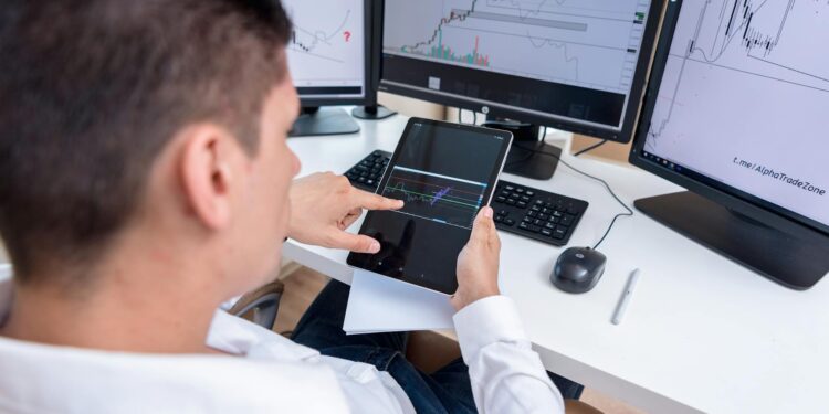 Trader analyzing cryptocurrency charts with Solana and memecoin visuals on a computer screen.