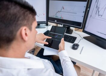 A person analyzing cryptocurrency charts with USDT logos and financial graphs displayed.