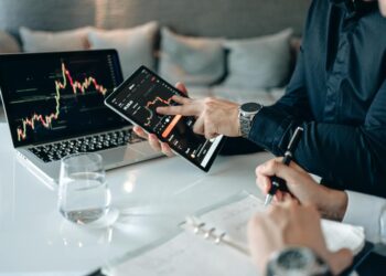 A person analyzing cryptocurrency data on a laptop with digital charts and graphs displayed.