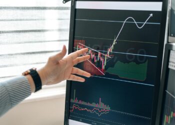 A financial analyst examines a chart showing XRP price trends and ETF performance.