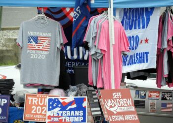 Donald Trump speaking at a podium with U.S. flags, warning against China's arms support to Iran.