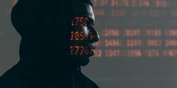 A hacker in a dark hoodie surrounded by digital code, highlighting cloud security breaches.