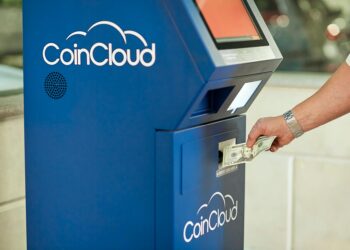 Bitcoin and crypto ATMs displayed in a public location with financial notices nearby.